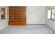 Open living area with built in wood shelving, neutral carpet, and large window offering lots of light at 14390 E Marina Dr # 104, Aurora, CO 80014
