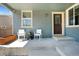 Inviting front porch with seating, a wooden door, and neutral-colored siding at 15378 W 50Th Pl, Golden, CO 80403