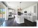Modern kitchen featuring white cabinets, stainless steel appliances, a large island, and dark hardwood floors at 15378 W 50Th Pl, Golden, CO 80403