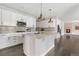 Contemporary kitchen featuring an island, white cabinetry, subway tile backsplash, and modern pendant lighting at 15378 W 50Th Pl, Golden, CO 80403