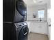 Clean laundry room with a stacked washer and dryer and a utility sink at 15378 W 50Th Pl, Golden, CO 80403