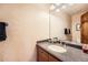 Bathroom features a granite vanity top with a designer sink and a wood-framed mirror at 2369 Bayberry Ln, Castle Rock, CO 80104
