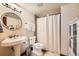 Bathroom featuring a pedestal sink, modern fixtures, and shower with neutral tile at 2369 Bayberry Ln, Castle Rock, CO 80104