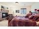 Cozy bedroom with a stone fireplace, comfortable armchair, and a large bed with decorative pillows at 2369 Bayberry Ln, Castle Rock, CO 80104
