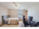 Well-lit bedroom with neutral carpet, ceiling fan, and a dark wooden door at 2369 Bayberry Ln, Castle Rock, CO 80104