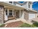 Inviting front porch with stone accents, a wooden bench, and the house number above the door at 2369 Bayberry Ln, Castle Rock, CO 80104