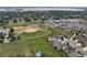 Aerial view showcases a residential neighborhood near baseball fields, tennis courts, a lake, and commercial area at 8071 Tabor St, Arvada, CO 80005