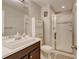 Bathroom with modern vanity, mirror, white cabinets, and a glass-enclosed walk-in shower at 8071 Tabor St, Arvada, CO 80005