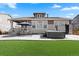 A backyard featuring a manicured lawn, patio dining set, and a luxurious hot tub, ideal for outdoor relaxation at 1931 Marlowe W Cir, Erie, CO 80516
