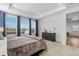 This bedroom features large windows offering breathtaking views, complemented by a stylish dresser and plush carpeting at 1931 Marlowe W Cir, Erie, CO 80516