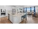 Bright open kitchen with stainless steel appliances, white cabinets, an island, and seating that overlooks the living room at 1931 Marlowe W Cir, Erie, CO 80516