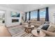 Bright living room with fireplace, TV, area rug, and large sectional couch that has a view from the window at 1931 Marlowe W Cir, Erie, CO 80516