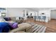 Open concept living area with adjacent dining and kitchen, featuring an L-shaped couch and barstool seating at 1931 Marlowe W Cir, Erie, CO 80516