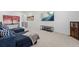 Spacious loft area with a comfortable blue couch, TV, and neutral decor, perfect for relaxation and entertainment at 1931 Marlowe W Cir, Erie, CO 80516