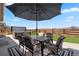 Relax on the patio with an umbrella, a table with chairs and a hot tub overlooking the grassy backyard at 1931 Marlowe W Cir, Erie, CO 80516