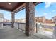 View from a charming front porch with stacked stone columns and a white railing at 1931 Marlowe W Cir, Erie, CO 80516