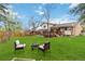 Green backyard with a fire pit, seating, wooden deck, and mature trees, great for recreation at 1768 E Jamison Ave, Centennial, CO 80122