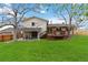 A spacious backyard with a covered patio, wooden deck, and lush green lawn, perfect for outdoor activities at 1768 E Jamison Ave, Centennial, CO 80122