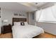 Neutral bedroom featuring hardwood floors, neutral walls, a decorative headboard, and natural light at 1768 E Jamison Ave, Centennial, CO 80122