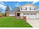Inviting two-story home with a well-maintained lawn, attached two-car garage, and neutral-colored siding at 1768 E Jamison Ave, Centennial, CO 80122