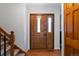 Warm and inviting foyer with a wooden front door, hardwood floors, and staircase on the left at 1768 E Jamison Ave, Centennial, CO 80122