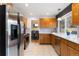 The kitchen showcases wood cabinets, stainless steel appliances, and an open view into the dining area at 1768 E Jamison Ave, Centennial, CO 80122