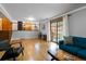 Bright living room with hardwood floors, a blue sofa, and sliding glass doors to the yard at 1768 E Jamison Ave, Centennial, CO 80122