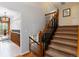 Carpeted staircase with wooden railing leading to the upper level, adjacent to a bright living area at 1768 E Jamison Ave, Centennial, CO 80122