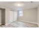 Finished basement area with light gray wood-look flooring, neutral walls, and a closet with sliding doors at 272 Balsam Ave, Brighton, CO 80601