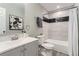 Modern bathroom features a shower over tub with black and white marble-look tiling and neutral walls at 272 Balsam Ave, Brighton, CO 80601