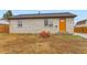 Home with a large boulder, freshly laid topsoil, new windows and inviting orange front door at 272 Balsam Ave, Brighton, CO 80601