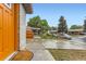 Home exterior with a concrete driveway, an orange front door, and a well-manicured front yard at 272 Balsam Ave, Brighton, CO 80601