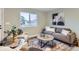 Cozy living room filled with comfortable seating, area rug, and a large window to let in natural light at 272 Balsam Ave, Brighton, CO 80601