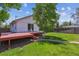 Private backyard with a spacious deck, lush grass, and mature trees at 1101 Spruce St, Louisville, CO 80027