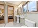 Bathroom featuring pedestal sink, neutral walls, tile floor, and wooden door trim at 1101 Spruce St, Louisville, CO 80027