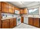 Well-lit kitchen with wooden cabinets, white appliances, and a window that offers natural light at 1101 Spruce St, Louisville, CO 80027