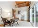 Bright home office with a glass-topped desk, vaulted ceiling, and a sliding glass door at 1101 Spruce St, Louisville, CO 80027