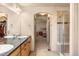 Bathroom with double sinks, walk-in shower, and a view of the bedroom, with access to closet and other areas at 2276 S Norse St, Lakewood, CO 80228