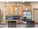 Stylish kitchen featuring light wood cabinets, granite countertops, stainless steel refrigerator, and pendant lighting at 2276 S Norse St, Lakewood, CO 80228