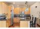 Bright kitchen boasts light wood cabinetry, stainless steel appliances, and a functional island with bar seating at 2276 S Norse St, Lakewood, CO 80228