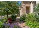Stone pathway leads through a garden filled with colorful flowers and greenery, framing the exterior of the house at 2276 S Norse St, Lakewood, CO 80228
