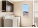 Bright laundry room with white appliances and dark cabinets offers a convenient and functional space at 2276 S Norse St, Lakewood, CO 80228