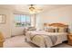 Cozy main bedroom with a comfortable bed, ceiling fan, and windows looking out to the neighborhood at 2276 S Norse St, Lakewood, CO 80228