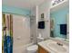 Clean bathroom features a tub with a shower, blue accent wall, and a classic white vanity at 2006 E 97Th Ave, Thornton, CO 80229