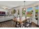 Bright dining area featuring a rustic wood table, modern light fixture, and backyard views through large windows at 2006 E 97Th Ave, Thornton, CO 80229
