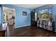 Living room with blue walls, vinyl record storage, and an open doorway to the kitchen at 2006 E 97Th Ave, Thornton, CO 80229