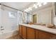 Well-lit bathroom with a shower-tub combo, modern fixtures, and a large vanity at 9654 Martin Luther King Jr Blvd, Denver, CO 80238