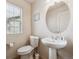 Cozy half bath includes a pedestal sink, toilet, and a window for natural light at 9654 Martin Luther King Jr Blvd, Denver, CO 80238