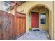 Inviting front entrance with a charming wooden gate and a vibrant red door under a sheltered archway at 9654 Martin Luther King Jr Blvd, Denver, CO 80238