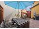 Cozy patio area features a wooden table set, blue umbrella, and barbecue grill at 9654 Martin Luther King Jr Blvd, Denver, CO 80238